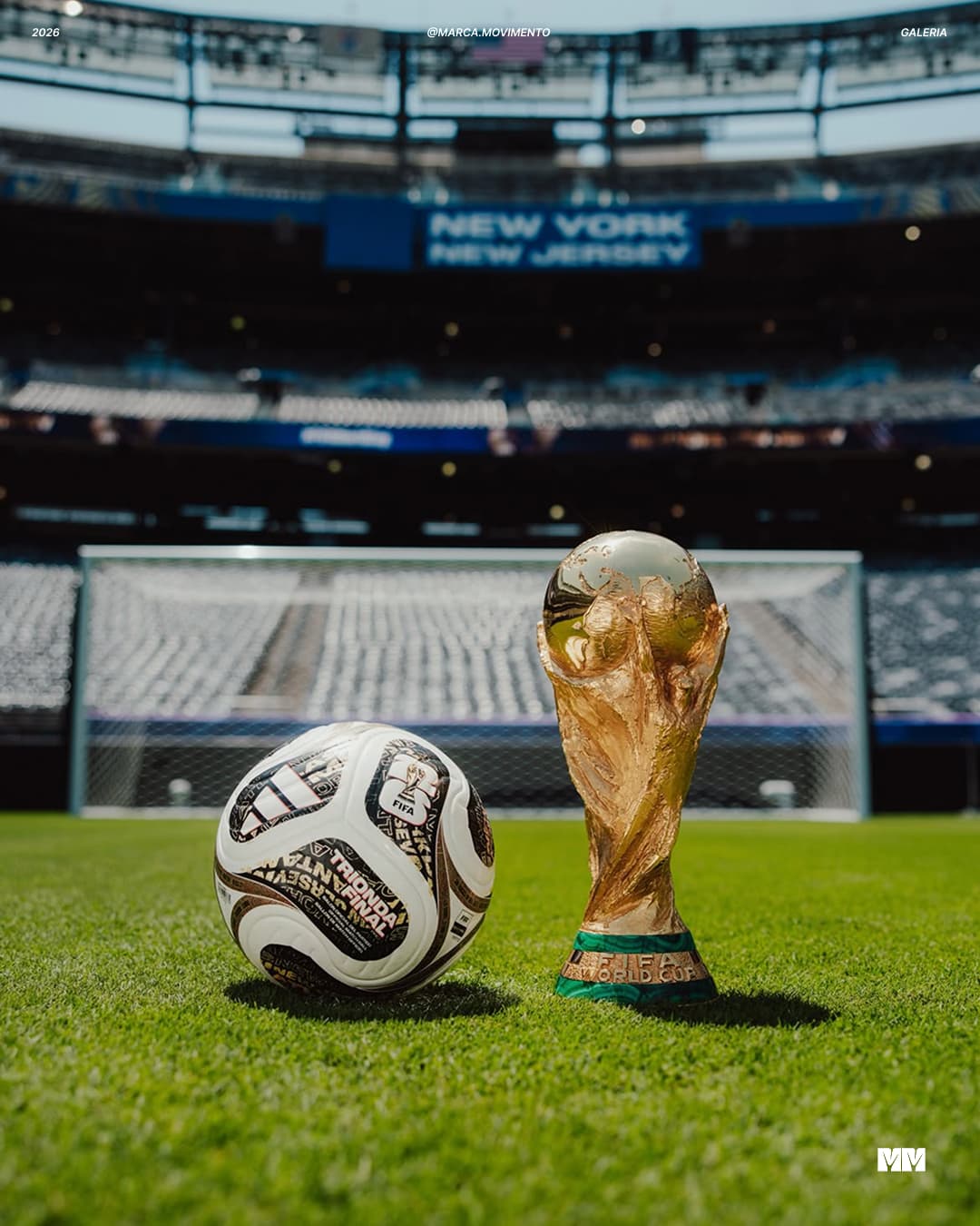 A bola Adidas Trionda Final ao lado da taça da Copa do Mundo no gramado do estádio de Nova York e Nova Jersey