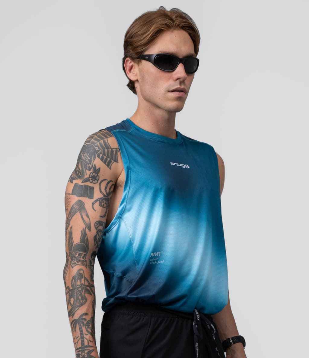 Corredor veste a regata AeroForm azul da linha Avant, da Snugg, em fundo neutro de estúdio