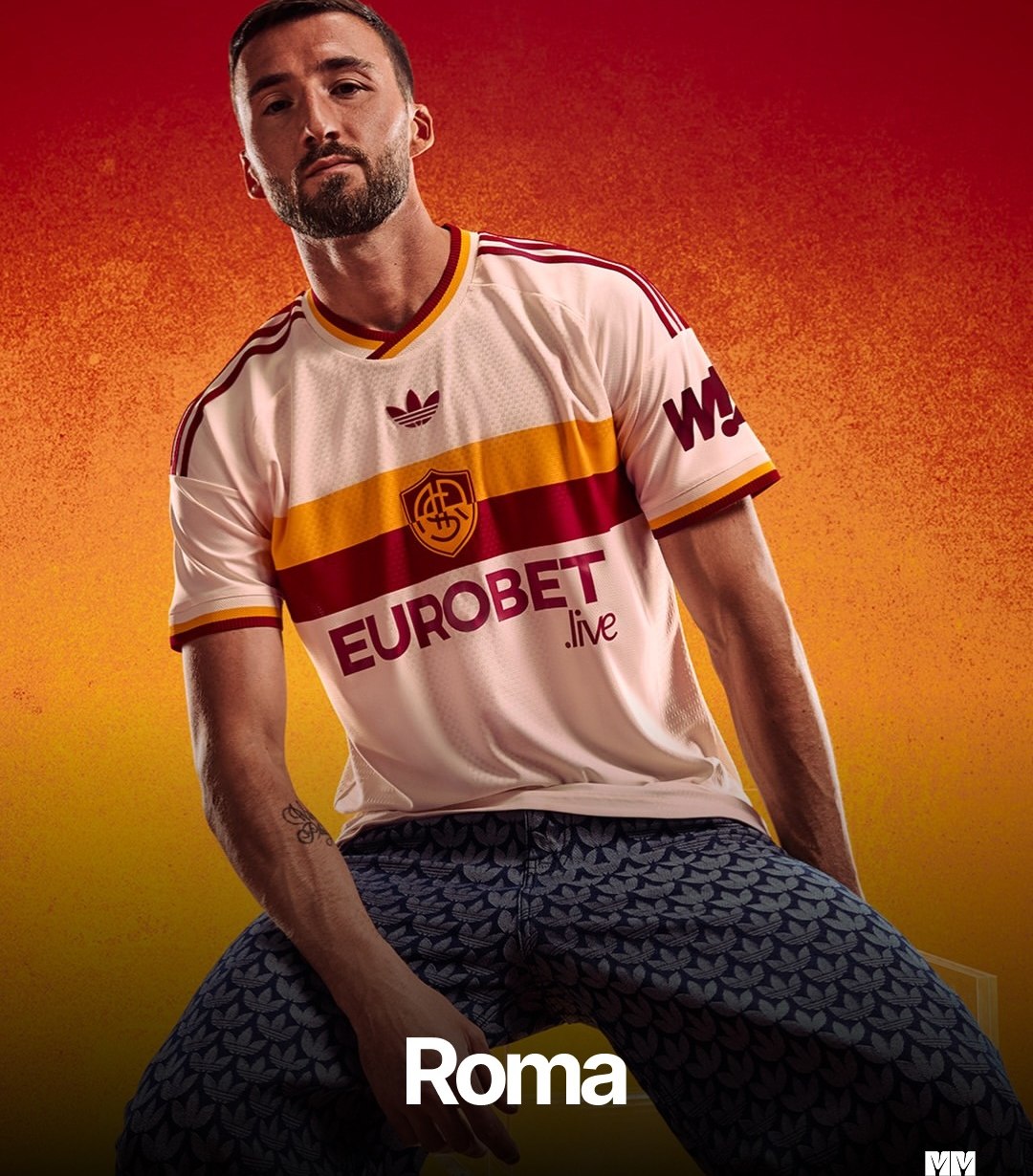 Camisa da Roma em creme com faixa amarela e vermelha e o Trefoil no peito, vestida por um jogador