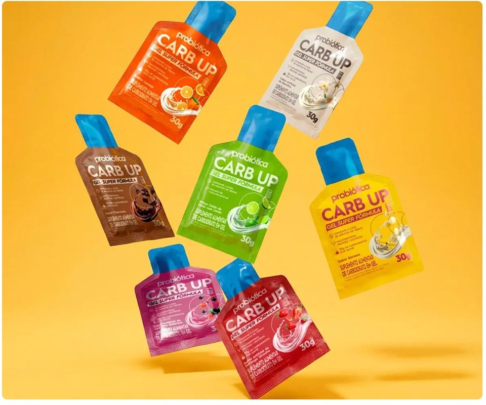 Sachês do gel Carb Up, da Probiótica, flutuando sobre fundo amarelo