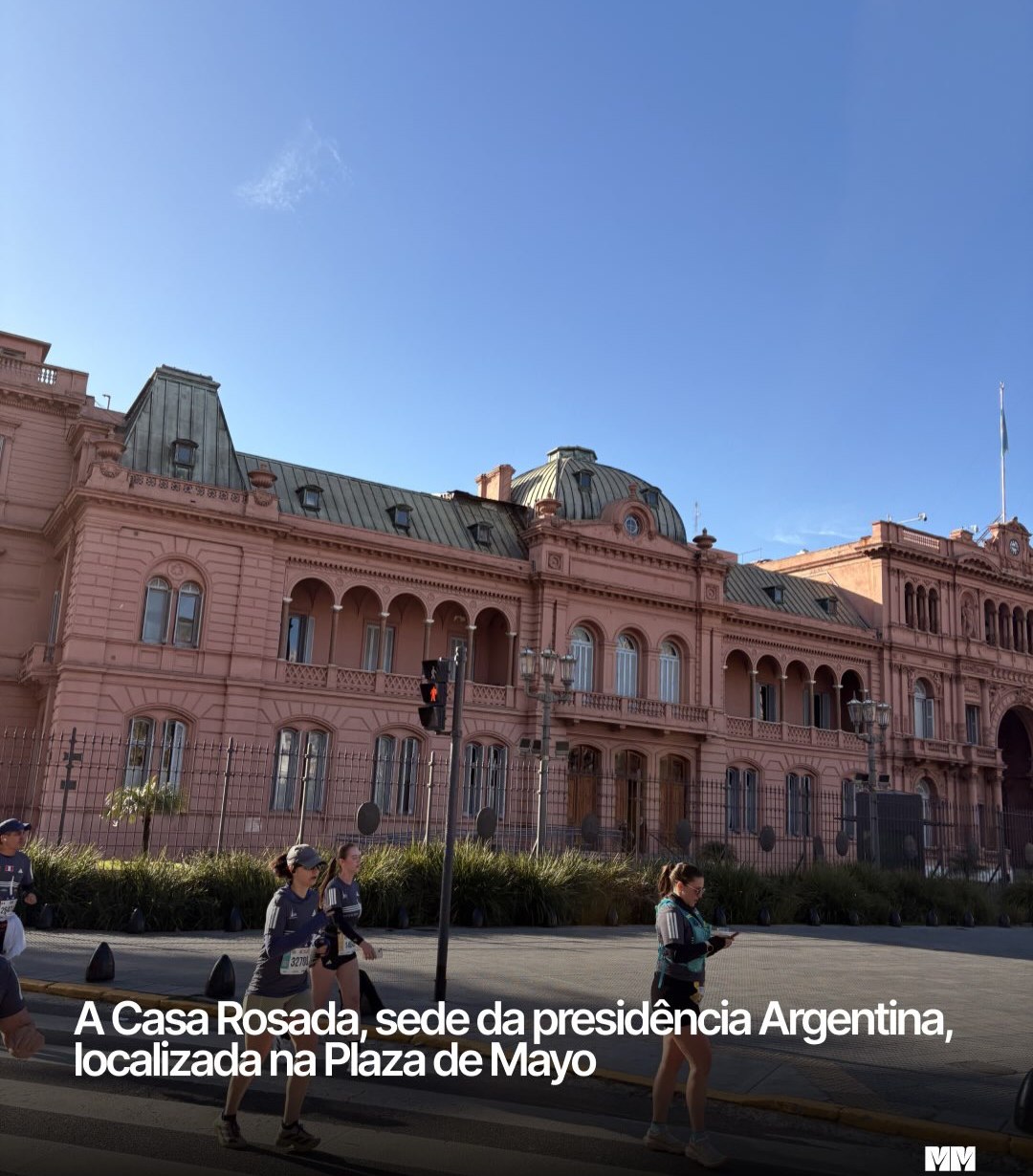 Fachada rosa da Casa Rosada, na Plaza de Mayo, com corredores passando em frente