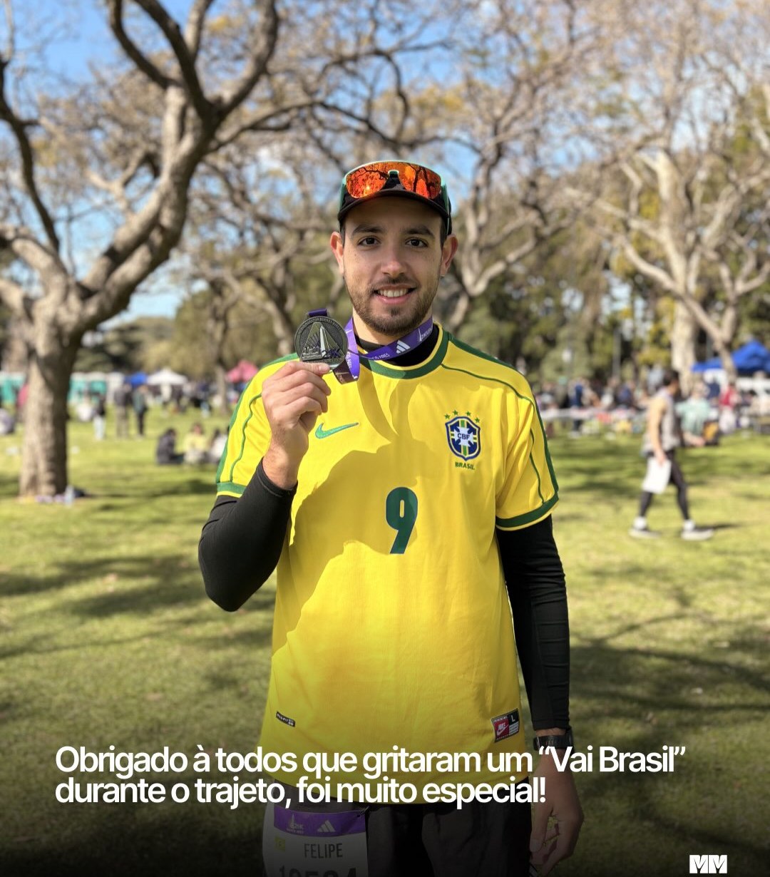 Homem com camisa amarela do Brasil segurando a medalha de finisher dos 21K de Buenos Aires