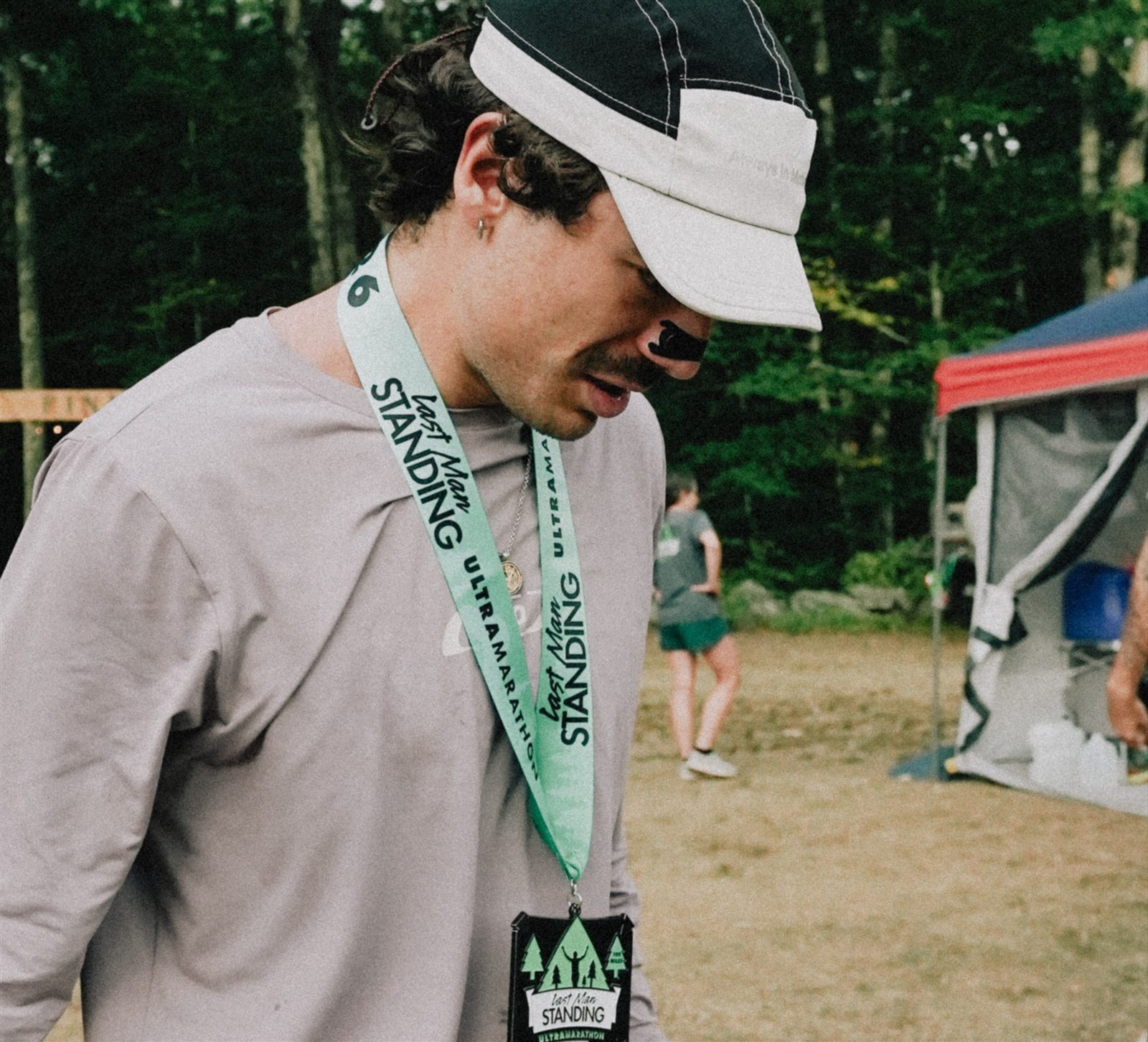 Pedro Nogueira de cabeça baixa, com a medalha e o cordão do Last Man Standing no pescoço