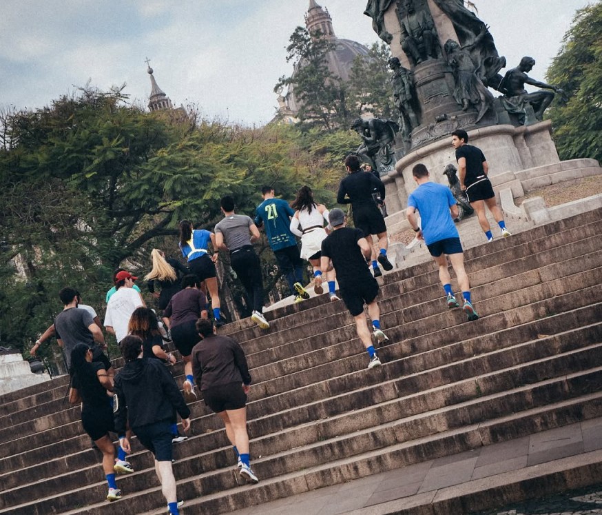Corredores do Salve Corre sobem a escadaria de um monumento em Porto Alegre