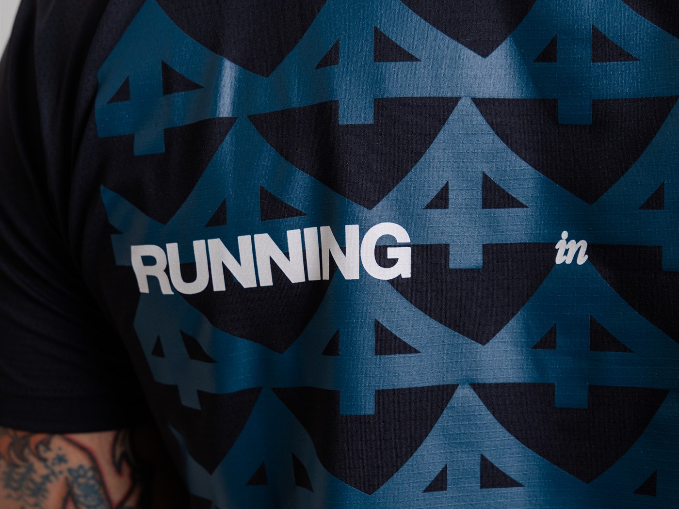 Detalhe da estampa em azul petróleo sobre a camiseta preta, com a palavra RUNNING em branco