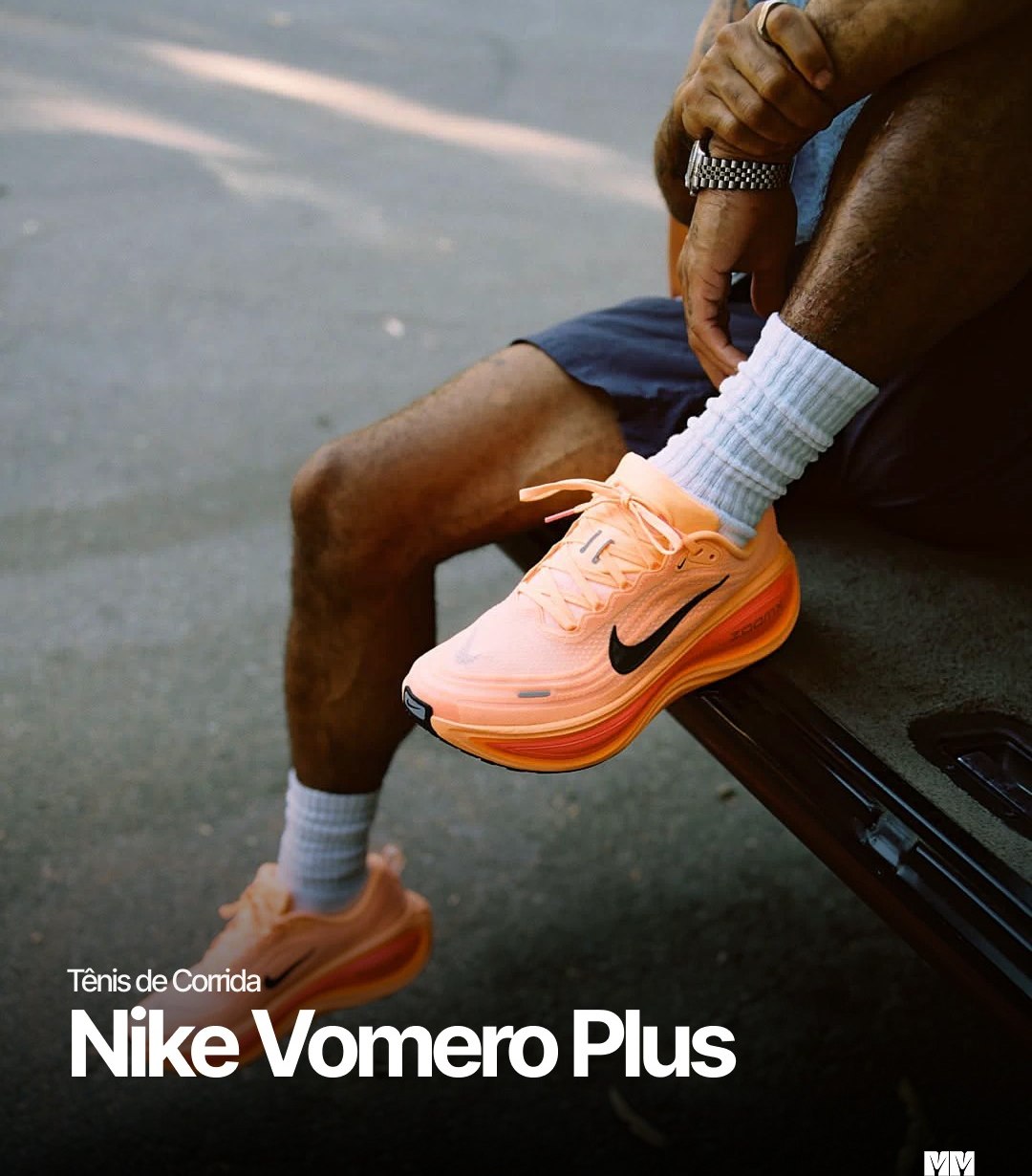 Corredor sentado calçando o Nike Vomero Plus laranja