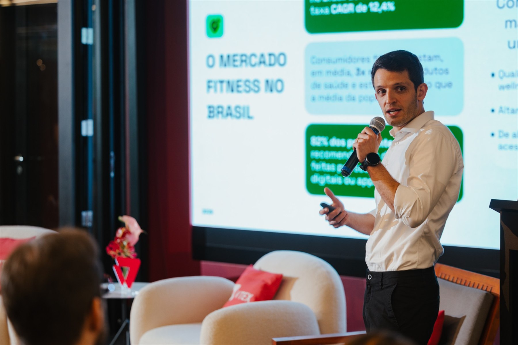 Executivo apresenta um slide intitulado O mercado fitness no Brasil, com dados de crescimento em caixas verdes e azuis